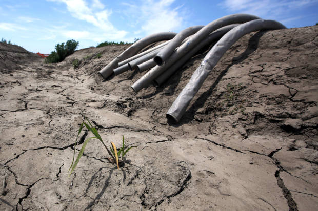 FILE - In this May 18, 2015 file photo, irrigation pipes sit along a dried irrigation canal on a field farmed by Gino Celli, who relies on senior water rights to water his crops, near Stockton, Calif. When water gets scarce and the government slaps restrictions on its use, farmers should be first in line at the spigot, according to an Associated Press-GfK poll released Monday, Aug. 3, 2015. (AP Photo/Rich Pedroncelli, File)